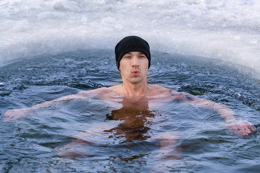 man plunging in frozen lake