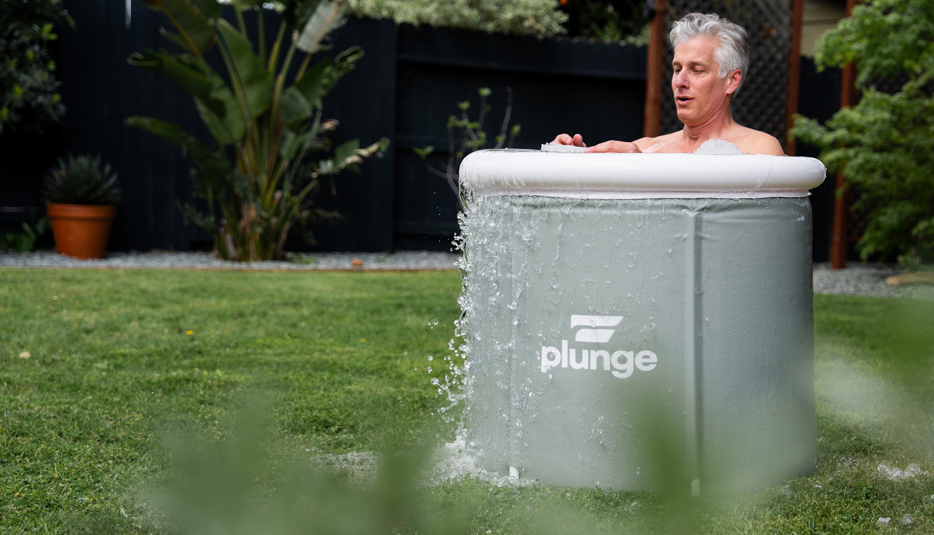 man in a pop-up cold plunge tub
