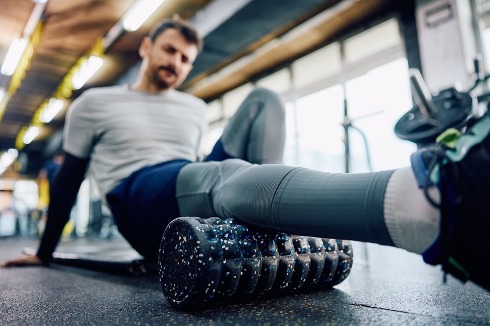 man using foam roller on his leg