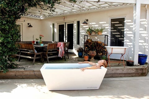 man in cold plunge tub in his backyard