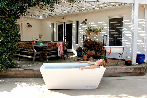 man in cold plunge tub in his backyard
