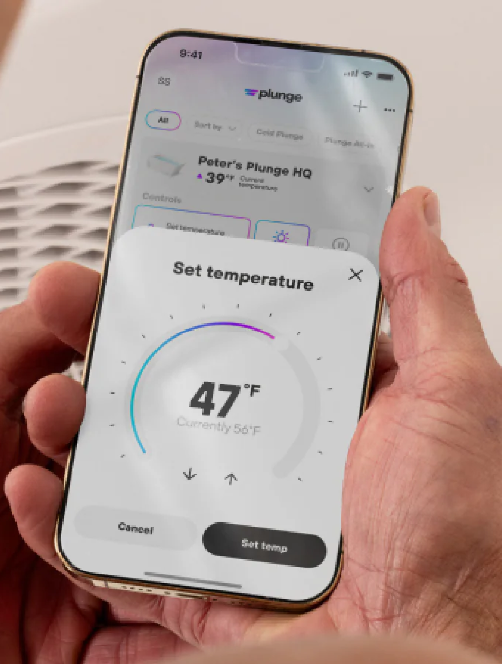 A person holds a smartphone displaying an app to set the temperature to 47°F.